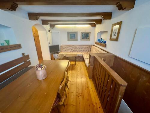 Cozy Apartment - Alverà في كورتينا دامبيتزو: غرفة طعام مع طاولة خشبية ومقعد