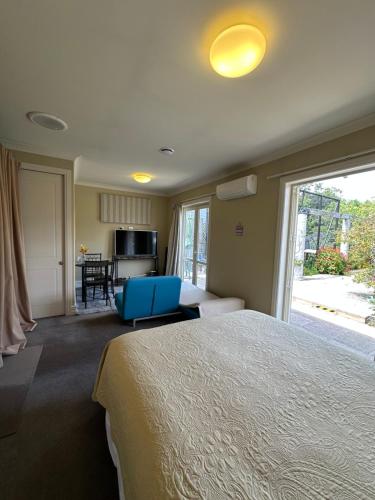 a bedroom with a large bed with a blue chair at Cosy & new CNZhouse with yard in Christchurch