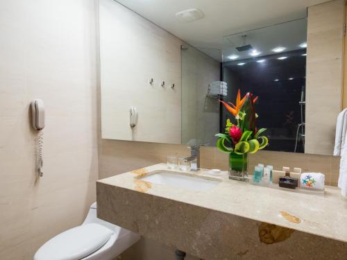 a bathroom with a sink and a toilet and a mirror at Las Americas Torre Del Mar in Cartagena de Indias