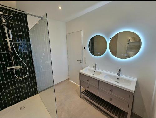 a bathroom with a sink and two mirrors at Gîte Familial in Nabringhen