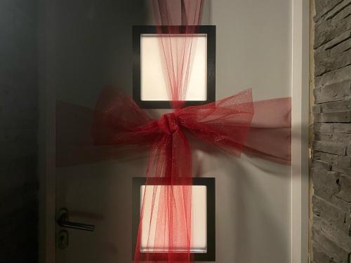 a red bow on a door with a window at Love House - Maison entière et son jardin - Rare à Paris in Paris