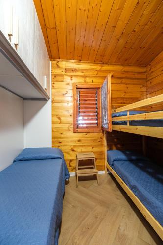 a bedroom with two bunk beds in a log cabin at Camping Villaggio Internazionale in San Menaio
