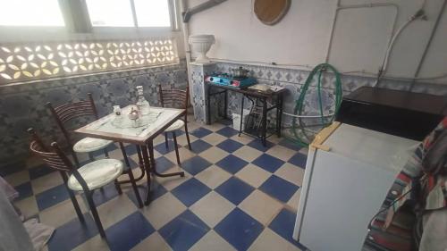 een kamer met een tafel en stoelen op een geruite vloer bij Dortoir ily in Constantine