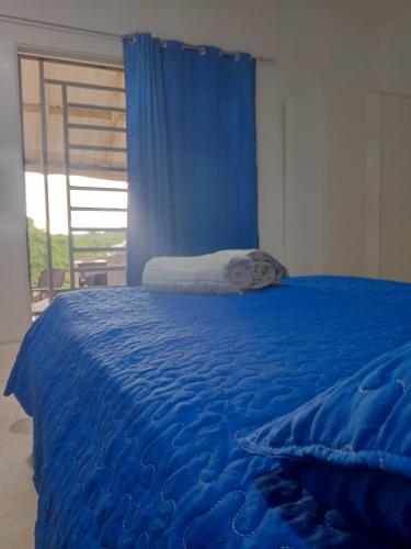 拉斯特拉纳斯Encuentra tu Alma的一张蓝色的床，铺着蓝色的床单，还有一扇窗户