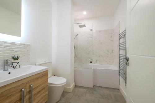 Un baño blanco con inodoro y ducha. en Modern 2 Bedroom Apartment, Free Parking, WiFi, en Gloucester