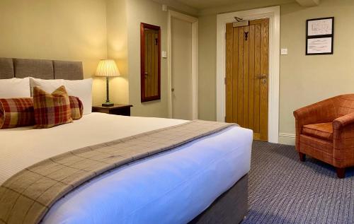 a hotel room with a large bed and a chair at Middle House - Wensleydale, Yorkshire Dales in Askrigg