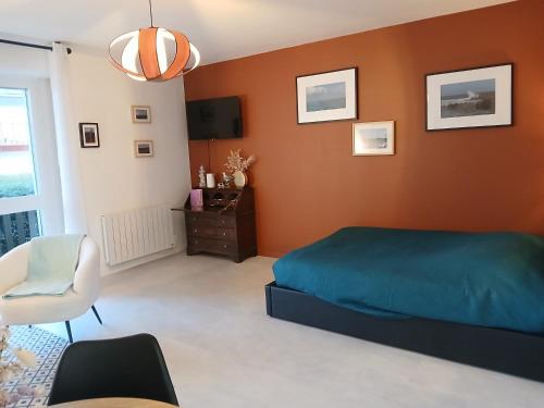 a bedroom with a blue bed and a chair at La Cabine du Man, meublé de tourisme classé 2 étoiles in Roscoff