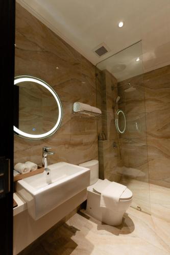 a bathroom with a sink and a toilet and a mirror at TQ Luxury Hotel & Apartment in An Khê