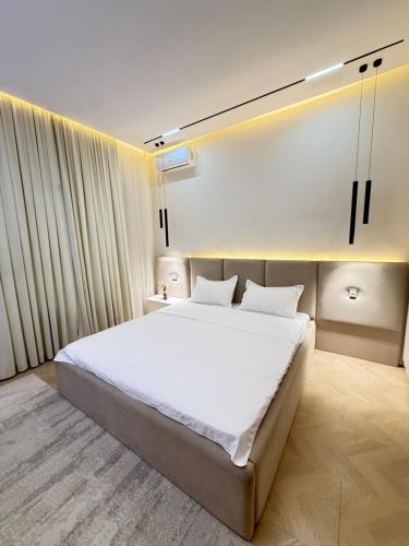 een slaapkamer met een groot bed met witte lakens bij Altair in Simkent