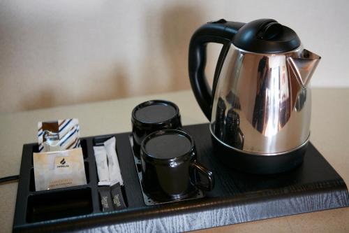 bandeja negra con tetera y dos tazas en Sercotel Las Artes Pinto, en Pinto