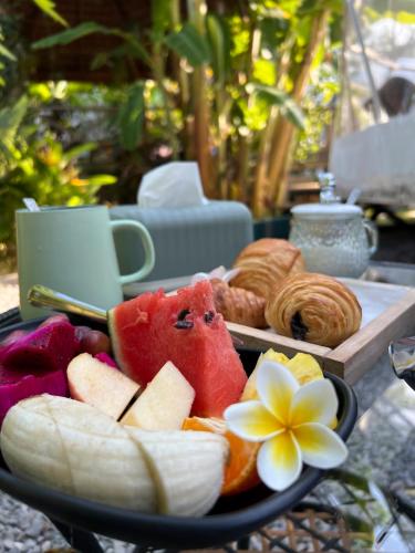 a plate of fruit and pastries on a table at Domea Thakhek - Urban Glamping in Thakhek