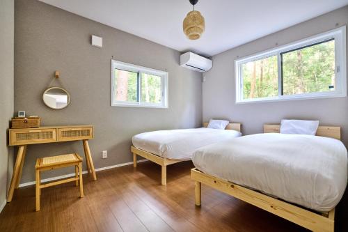 two beds in a room with two windows at ヘルシンキ in Fujikawaguchiko