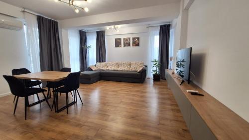 een woonkamer met een tafel en een bank bij Sara Apartament in Craiova