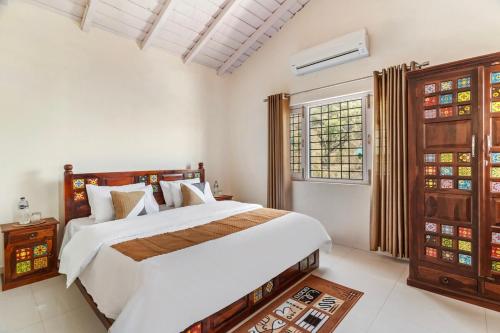 una camera da letto con un grande letto bianco e una finestra di Lakeview House 7 mins to Bhimtal Lake3BHK2Bath a Bhimtal