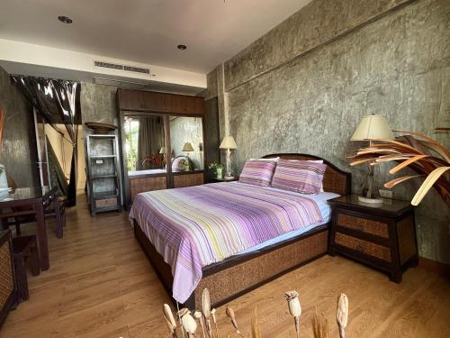 a bedroom with a large bed and a table at WiNNiNE Cozy Home in Bangkok