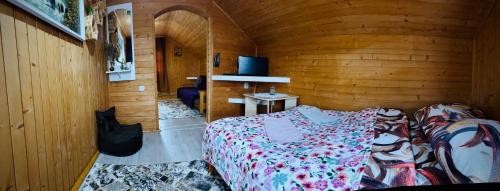 a bedroom with a bed in a wooden room at Sadiba Rozchil in Yablunytsya