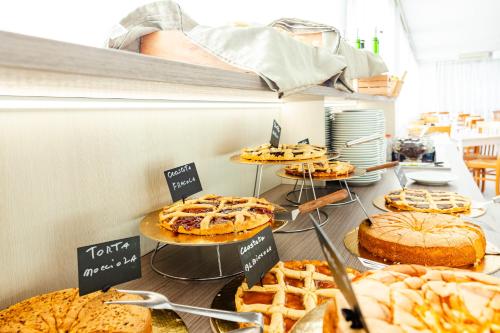 Eine Auswahl an Kuchen und Torten ist in einer Bäckerei ausgestellt. in der Unterkunft Brora Family Village in Lido di Savio