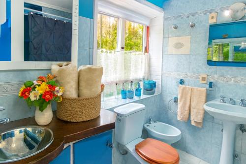 Un baño azul con inodoro y lavabo. en Casa Gloria con Piscina - Jacuzzi exterior climatizada Relax Playa, en Punta del Este