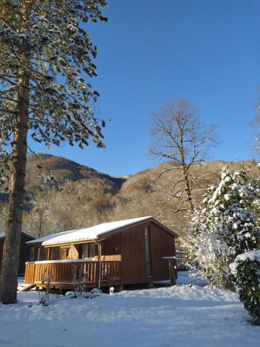 una baita nella neve con alberi e una montagna di Camping Le Coulédous ad Aulus-les-Bains