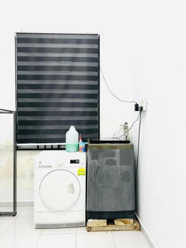 a washing machine sitting next to a wall at Inap Indah in Kuantan