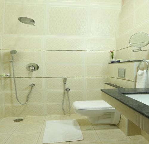 a bathroom with a shower and a toilet and a sink at TNV Casita Inn in Yercaud