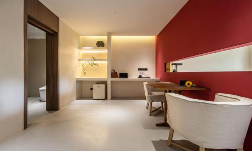 a dining room with red walls and a table and chairs at Siguniang Mountain Waiting for the Wind Snow Mountain Guesthouse in Mount Siguniang
