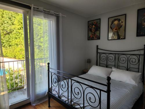 a bedroom with a black bed and a balcony at L'ECRIN DU LAC - L'Ortencia in Mazamet