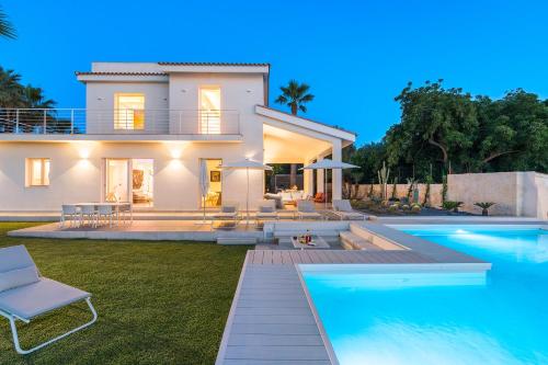 a villa with a swimming pool in front of a house at Artemare in Plemmirio