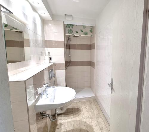 a white bathroom with a sink and a shower at Boddenhof Apartment 50 - modern und freundlich, viel Sonne in Buschvitz