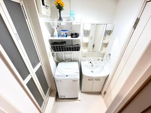 een kleine badkamer met toilet en wastafel bij Camelot House 南福岡 in Fukuoka