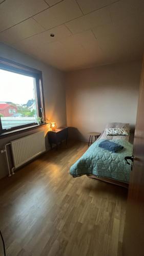 a bedroom with a bed and a large window at Guesthouse Leon in Tórshavn