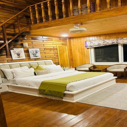 a large white bed in a room with wooden walls at Megha Resort & Villas, Dehradun-Where Nature Pampers You in Dehradun