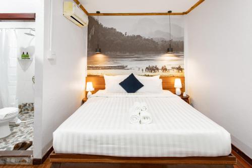 a bedroom with a bed with a painting on the wall at BlueHome Free Laundry in Vientiane