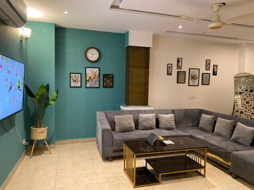 ein Wohnzimmer mit Sofa und Fernseher in der Unterkunft 2 Bedroom Executive Suite in DHA Phase 8 in Lahore
