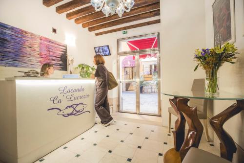 a woman standing at a counter in a store at Locanda Ca' Lucrezia in Venice
