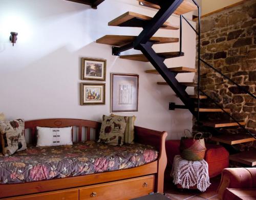 a living room with a couch and a staircase at La Quintana de Antón in Jomezana