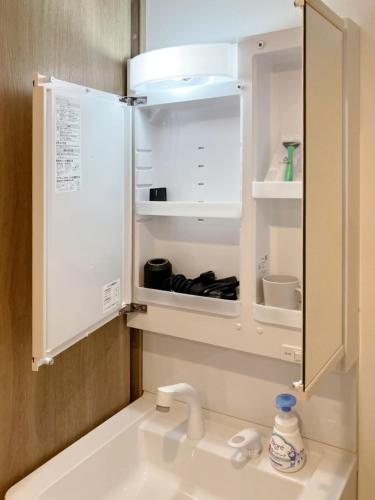 a bathroom with a sink and a refrigerator at カレラ豊平2nd in Sapporo