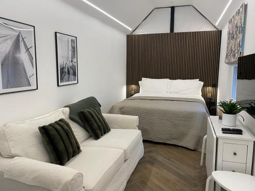 Boutique Cottage by Bishop's Stortford train station, easy to Stansted Airport & Parking في بيشوبس ستورتفورد: غرفة معيشة بها سرير وأريكة