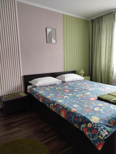 a bedroom with a bed with a colorful blanket at Elena in Rivne