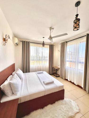 ein Schlafzimmer mit einem großen Bett und einem großen Fenster in der Unterkunft Seville Stays Cozy Getaway in Mombasa