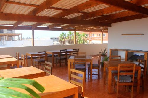 a restaurant with wooden tables and chairs and windows at Residence A Paz in Boa Ventura