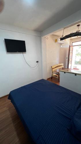 a bedroom with a blue bed and a tv on the wall at Mar y Mar Zipolite in Zipolite