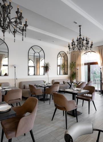 a dining room with tables and chairs and a couch at Mountain View Boutique Hotel in Almaty