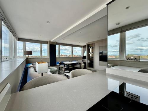 ein Wohnzimmer mit Tisch und Stühlen und Fenstern in der Unterkunft Large luxury apartment in Central Harrogate in Harrogate