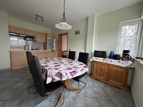 a kitchen with a table and chairs and a dining room at Bennis Rodelhaus in Oberhof