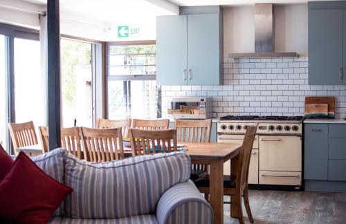 cocina con mesa, sillas y sofá en AtSupers Accommodation, en Jeffreys Bay