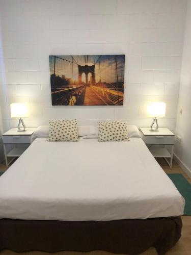 a large white bed in a room with two lamps at Apartamento de 70 m2 en el Arroyo de la Vega , Alcobendas in Alcobendas