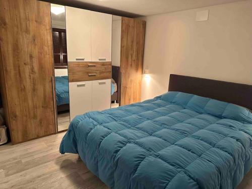 Un dormitorio con una gran cama azul en una habitación. en Faido Apartment, en Faido