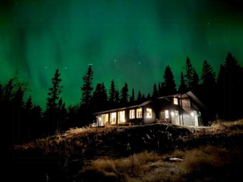 Una vieja cabaña bajo las estrellas y la aurora boreal. en New Cabin With Mountain View In Bittermark, Trysil, en Trysil