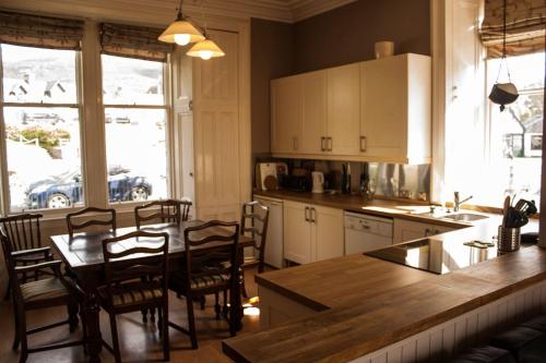 cocina con mesa, sillas y encimera en Auld Bank House, en Braemar